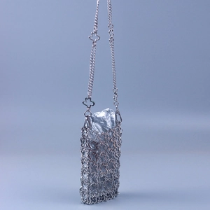 Macro view of silver floral hollow-out metal mesh and reflective inner pouch