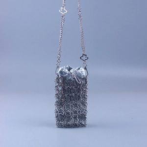 Detail of silver clover metal woven mini bucket bag with glossy drawstring pouch