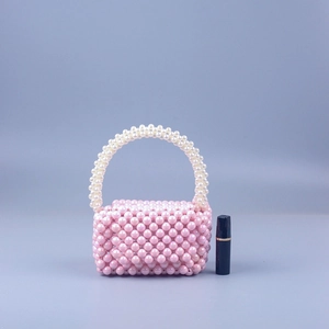 Detail view of handmade mini pearl handbag with pink beads and white top handle