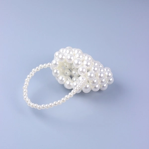 Detail of handcrafted mini pearl beaded handbag with circular top handle and lustrous finish