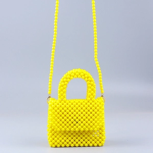 Detail view of yellow acrylic handmade beaded handbag with matching crossbody strap