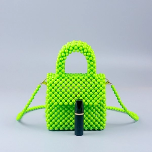 Neon green handmade beaded tote bag with crossbody strap and lipstick for size reference