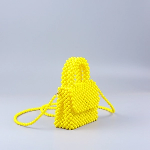 Detail of handcrafted bright yellow acrylic beaded handbag with detachable strap
