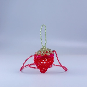 Detailed view of handmade beaded mini bag in 3D strawberry shape with crossbody chain