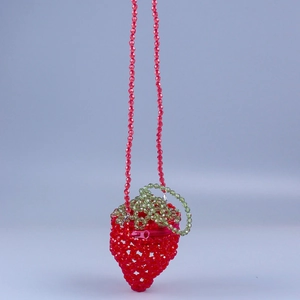 Detailed macro view of the strawberry-shaped acrylic beaded bag with a red zipper closure