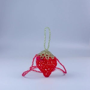 Handmade strawberry beaded crossbody bag with green leaf top and red shoulder strap