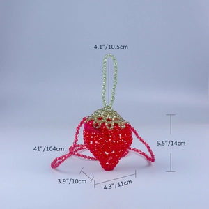 Macro shot of handmade red beaded strawberry bag showing precise beadwork and green leaf detail