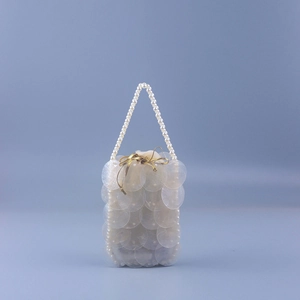 Detailed view of handmade fish scale sequin bag with elegant white pearl bead handle strap