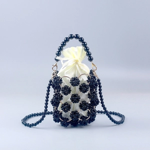 Detail of handmade black beaded bucket bag with cream satin drawstring lining and gold hardware