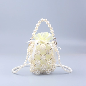 Handwoven pearl bucket bag with gold metal rings and satin drawstring inner pouch