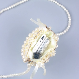 Detail view of mini pearl beaded bag showing interior capacity with essentials