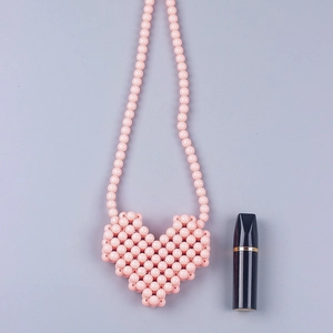 Dettaglio della mini borsa a tracolla fatta a mano con perline rosa a forma di cuore
