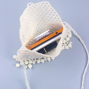 Sac à bandoulière en perles blanches avec pompons contenant téléphone et maquillage