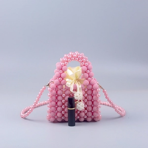 Close-up of pink pearl beaded handbag with satin drawstring liner and lipstick for scale