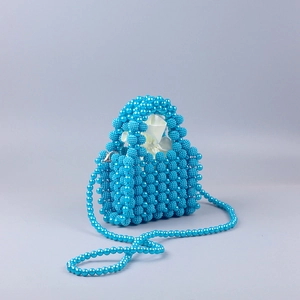 Detail of blue handmade beaded handbag with pearl texture, satin lining and strap