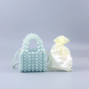 Detailed shot of handmade pearl beaded handbag with satin dust bag and long chain