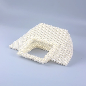Détail d'un sac à main fait main en perles blanches tressées avec une finition élégante et douce