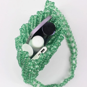 Handgefertigte grüne Perltasche mit Handy und Kosmetik zur Platzanzeige