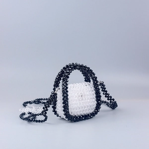 Detail of handcrafted acrylic beaded crossbody bag with floral cutout shoulder strap