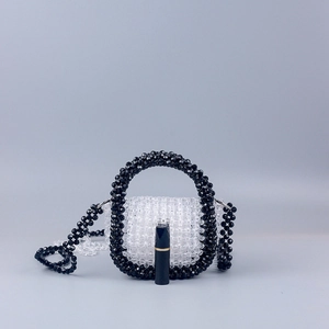 Mini acrylic beaded handbag shown with lipstick for scale, featuring black round handle