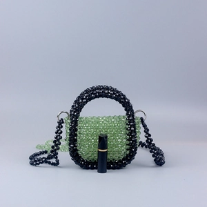 Green acrylic bead handbag with black accents and a floral pattern beaded shoulder strap
