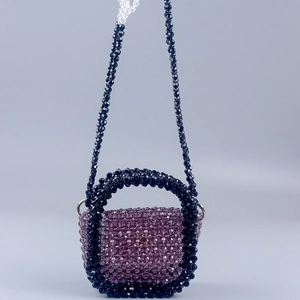 Detail of handcrafted purple and black acrylic beaded mini bag with woven shoulder strap