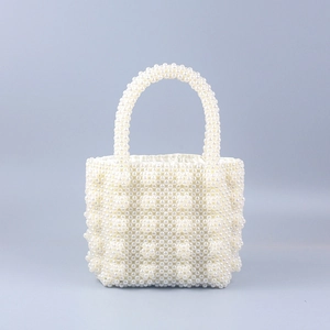Detailed view of handmade pearl handbag featuring spherical weave and satin lining