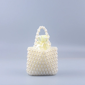 Detail of handmade pearl woven handbag showing ivory beads and satin drawstring liner