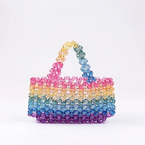 Macro detail of handmade rainbow beaded handbag showing colorful acrylic beads and weaving