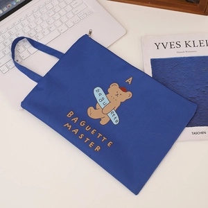 Royal blue A4 canvas document bag with cute cartoon bear and zip closure shown on a desk