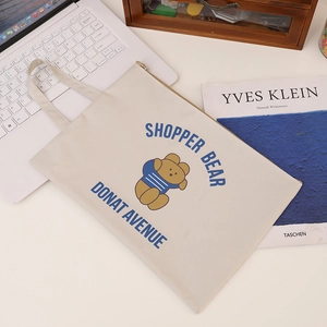 Close-up of A4 Oxford fabric bag with bear illustration and zipper on a desk