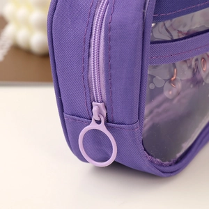 Dettaglio dell'astuccio viola in tessuto con ampia zip circolare e finestra trasparente