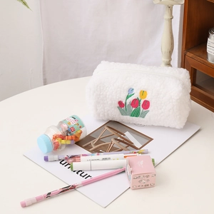 Detail of plush white makeup bag with colorful tulip embroidery and soft texture
