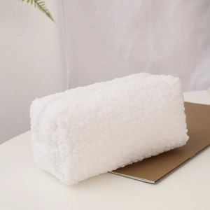 Close-up of white plush makeup bag with soft fleece texture and top zipper closure
