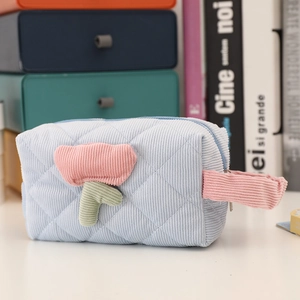 Close-up of light blue corduroy makeup bag with 3D tulip embroidery and pink strap