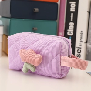 Close-up of purple quilted corduroy makeup bag with 3D tulip floral detail and handle