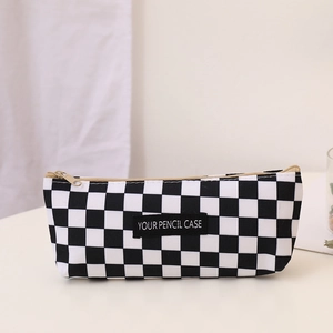 Detail of checkered canvas pencil case with gold zipper and custom brand label