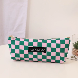 Close-up of canvas pencil case featuring pink and green checkerboard pattern with gold zipper