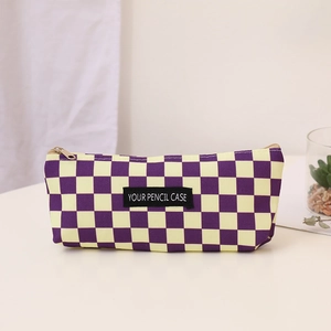 Detailed close-up of purple and yellow checkerboard canvas pencil case with woven label