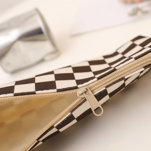 Close-up of durable checkerboard canvas pencil case featuring a smooth metal zipper