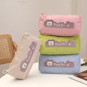 Close-up of four-color corduroy pencil cases featuring cute bear patches and metal zippers