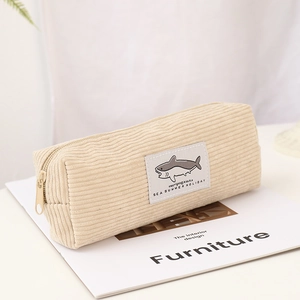 Détail macro de la trousse en velours côtelé beige avec motif requin et zip métallique