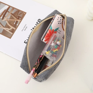 Détail macro de l'intérieur de la trousse en velours gris avec des fournitures