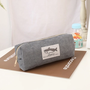 Détail trousse en velours côtelé gris avec motif requin et fermeture éclair jaune