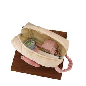 Cream corduroy makeup bag with pink handle and tulip detail in a 45-degree angle view