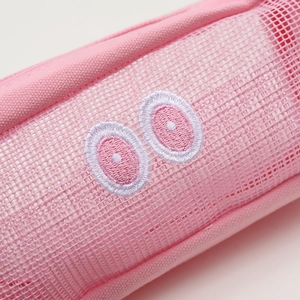 Detailed view of pink mesh pencil case featuring cute embroidered eye motifs and zipper