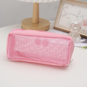 Close-up of pink mesh pencil case with canvas trim and zipper in a lifestyle setting