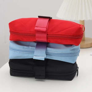 Detailed stack of nylon pencil cases in red, blue, and black with reinforced strap