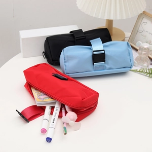 Detail of minimalist waterproof pencil cases in red, blue, and black with buckle strap