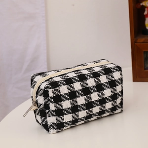 Close-up of black and white checkered canvas pouch with durable zipper and woven texture